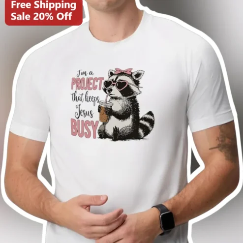 I'm A Project That Keeps Jesus Busy Tee Christian Faith Graphic Shirt Coffee Raccoon Gift