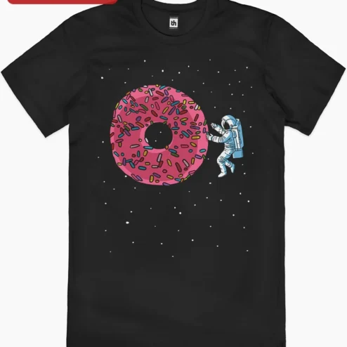 Astronaut and Donut Space Illustration Tee Funny Whimsical Sci-Fi Graphic Shirt Gift for Space Enthu on a hanger, ready to ship from Chicago, Illinois