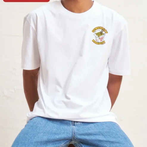 Democracy Manifest Tee Political Slogan Shirt Activist Apparel on a hanger, ready to ship from Chicago, Illinois