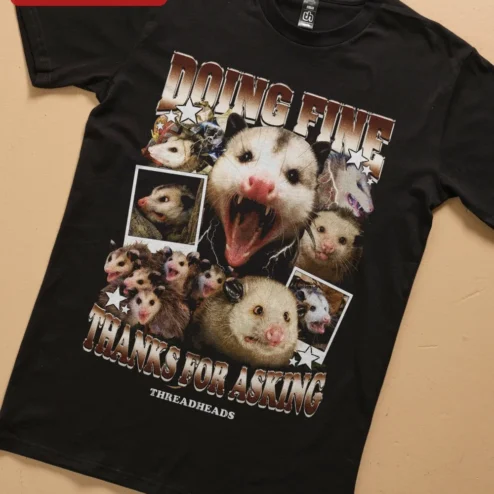 Doing Fine Thanks For Asking Opossum Graphic Tee Sarcastic Mental Health Humor Shirt on a hanger, ready to ship from Chicago, Illinois