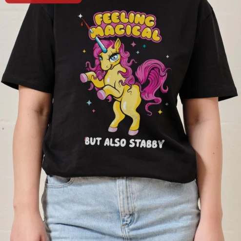 Feeling Magical But Also Stabby Unicorn Graphic Tee Funny Fantasy Humor Shirt on a hanger, ready to ship from Chicago, Illinois