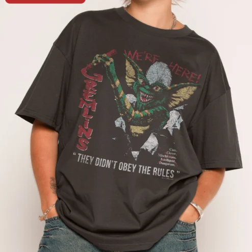 Gremlins We're Here Stripe Tee Cute Clever Mischievous Dangerous Horror Movie Shirt on a hanger, ready to ship from Chicago, Illinois
