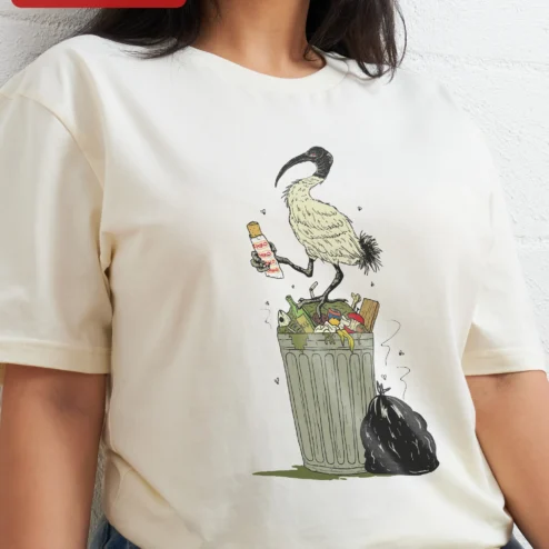 Ibis Eating Trash Funny Animal Illustration Tee Bin Chicken Meme Shirt for Bird Lovers on a hanger, ready to ship from Chicago, Illinois