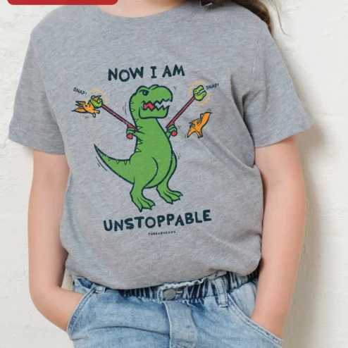 Now I Am Unstoppable Dinosaur Kids Tee Funny T-Rex Graphic Shirt for Boys Girls on a hanger, ready to ship from Chicago, Illinois