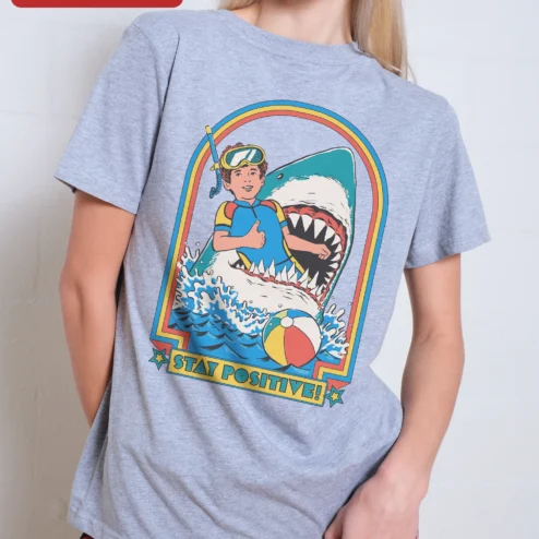 Stay Positive! Retro Shark Surf Graphic Tee on a hanger, ready to ship from Chicago, Illinois