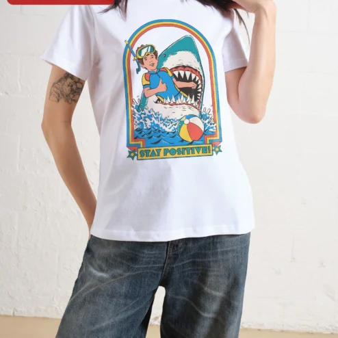 Close-up of Stay Positive! Retro Shark Surf Graphic Tee for streetwear fans in Chicago, Illinois