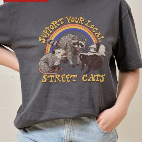 Support Your Local Street Cats Tee Funny Retro Trash Animals Graphic Shirt Gift for Cat Lovers on a hanger, ready to ship from Chicago, Illinois