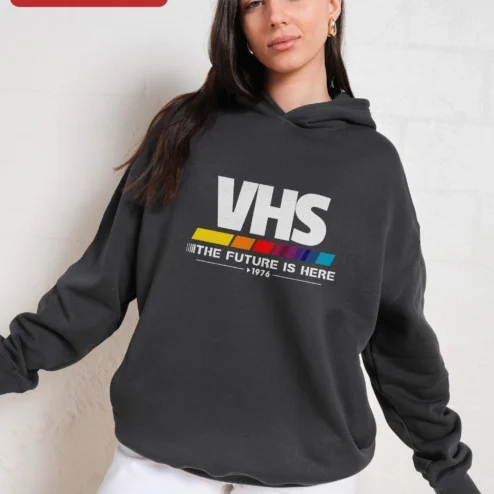 VHS The Future Is Here 1976 Retro Hoodie on a hanger, ready to ship from Chicago, Illinois