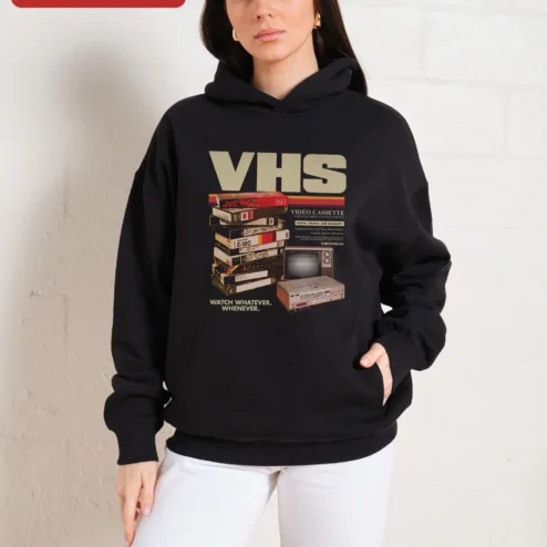 VHS Watch Whatever Whenever Retro Horror Hoodie on a hanger, ready to ship from Chicago, Illinois