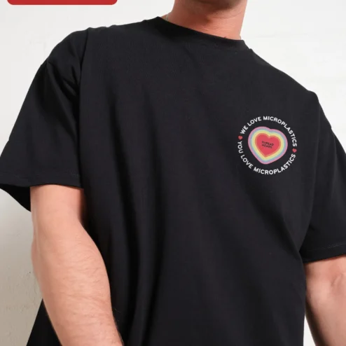 We Love Microplastics Satirical Eco Awareness Tee Unisex Cotton Graphic Shirt on a hanger, ready to ship from Chicago, Illinois