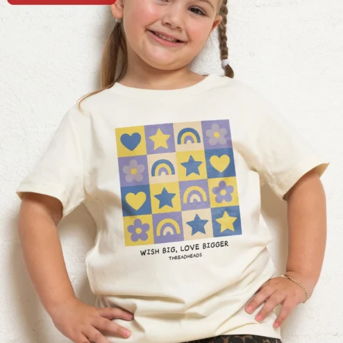 Wish Big Love Bigger Kids Tee Girls Inspirational Rainbow Heart Star Graphic Shirt on a hanger, ready to ship from Chicago, Illinois